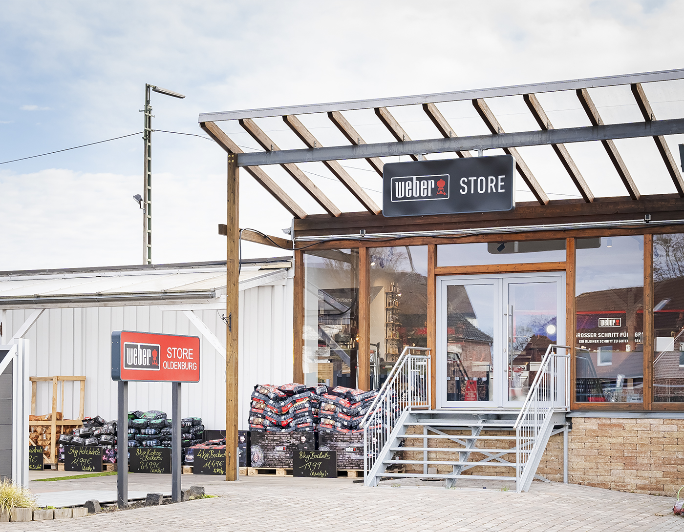 Eingangsbereich des Weber Store Oldenburg mit Treppe, Grillzubehör und Holzpellets