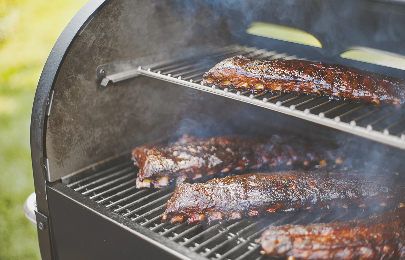 Saftige Spareribs auf einem Smoker-Grill in der Zubereitung