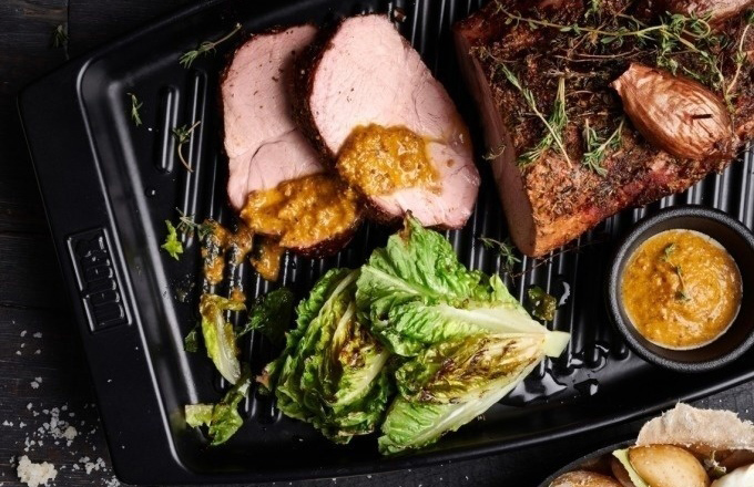 Grillplatte mit Fleisch, gegrilltem Salat, Zwiebeln und Dip