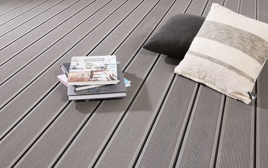 Kissen und Zeitschriften auf modernen Terrassendielen aus WPC
